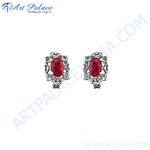 Load image into Gallery viewer, Silver stud earrings featuring oval-cut red ruby gemstones, set in a decorative silver frame