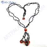 Load image into Gallery viewer, Black beaded necklace with red gemstone and silver accents displayed on a white background.