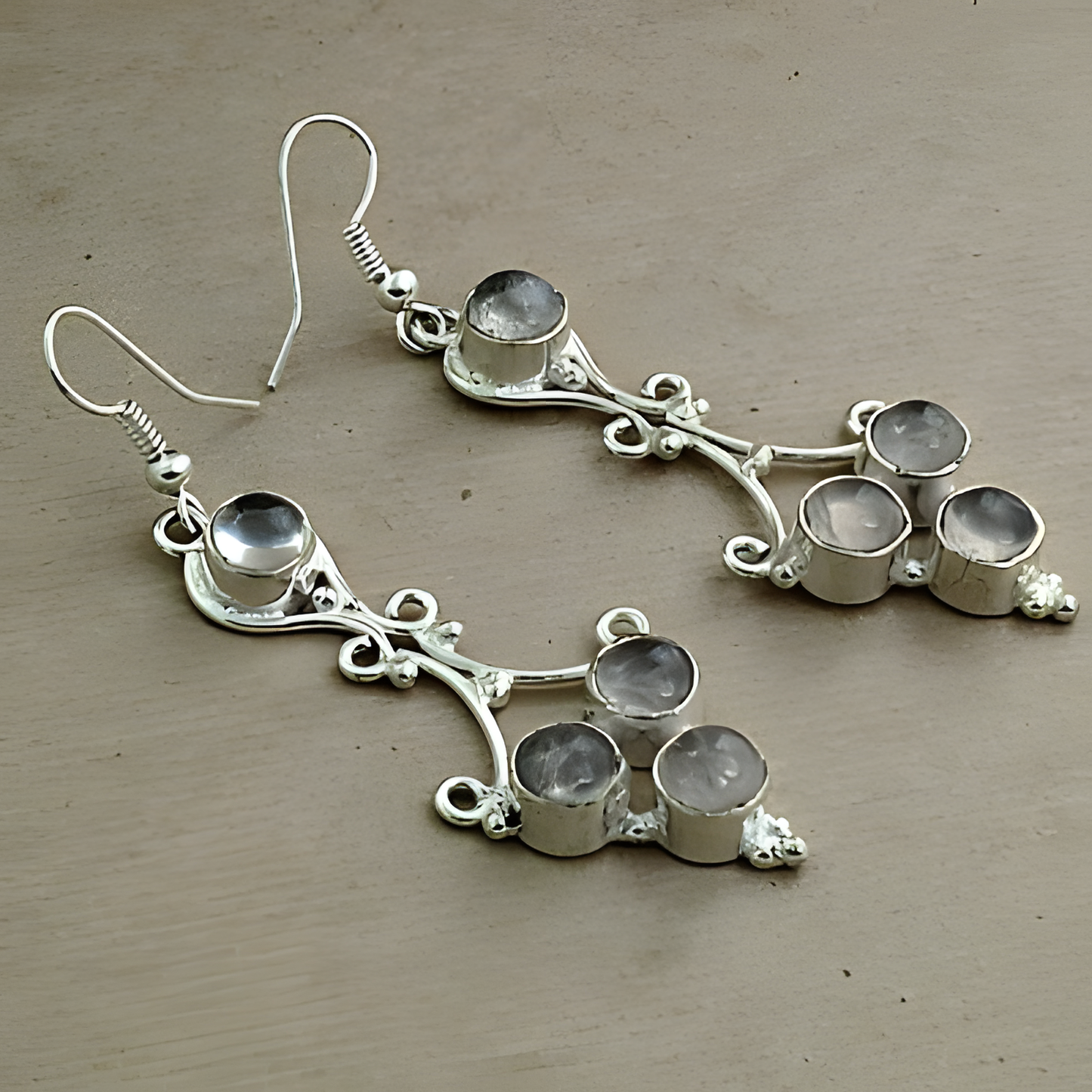 Sterling silver dangle earrings with multiple gemstones on a neutral background.