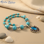 Load image into Gallery viewer, Turquoise bead necklace with a silver pendant featuring a blue gemstone and surrounding purple accents.