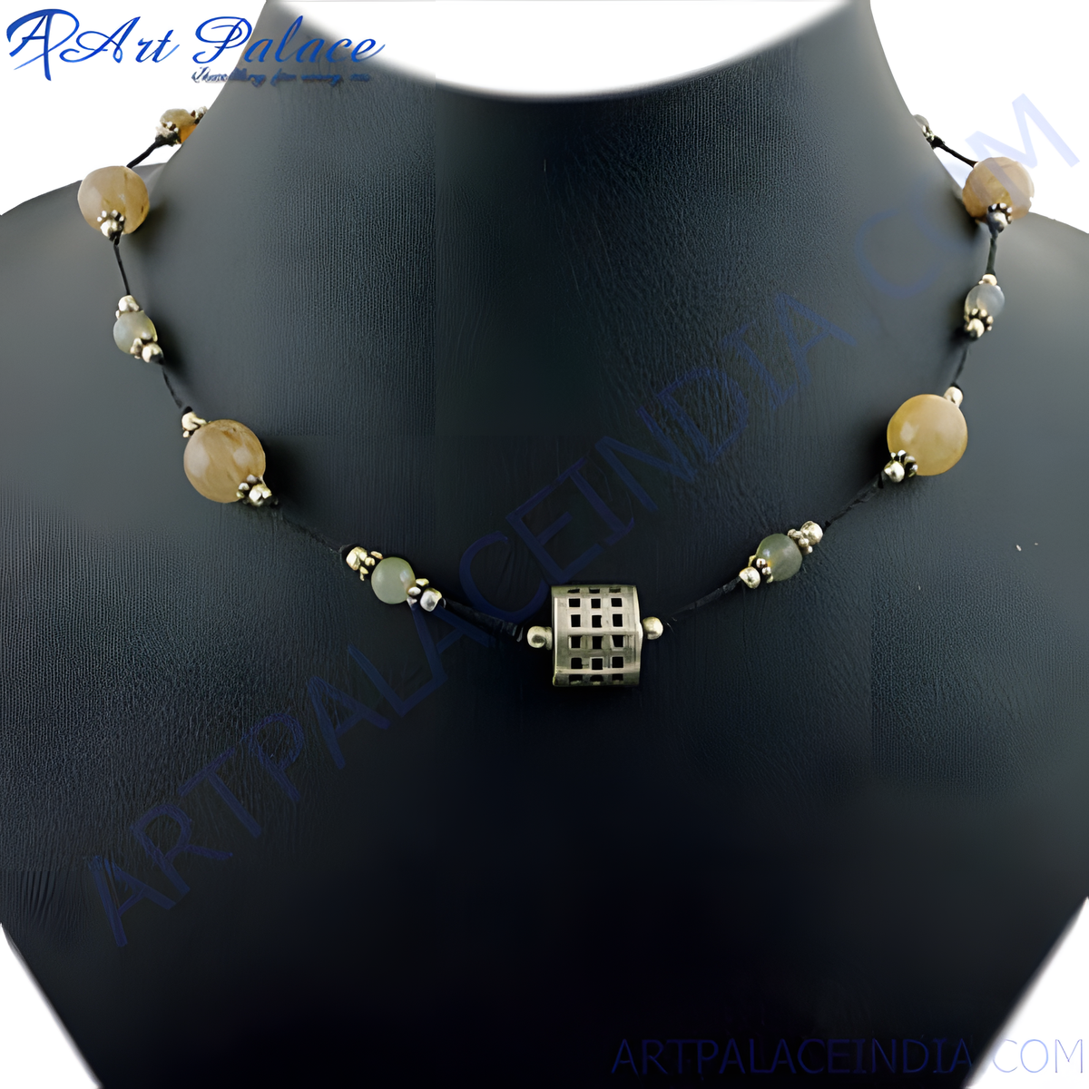 A beaded necklace with yellow and green stones strung on a black cord, on a black jewelry stand