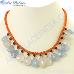 Load image into Gallery viewer, A beaded necklace with orange beads and teardrop-shaped chalcedony and garnet gemstones.
