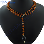 Load image into Gallery viewer, Carnelian bead lariat necklace on a black jewelry display, featuring orange gemstone beads and a geometric black pendant.
