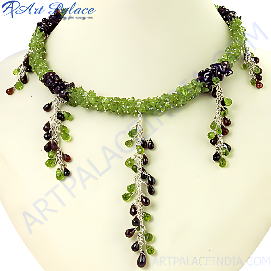 Green peridot and garnet beaded necklace with sterling silver accents. Features teardrop gemstone dangles.