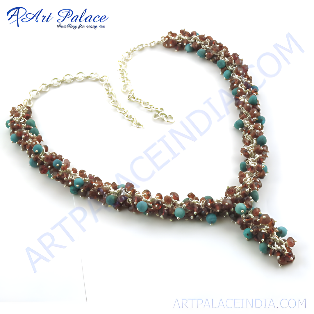 Turquoise and garnet beaded necklace with sterling silver chain on a white background.
