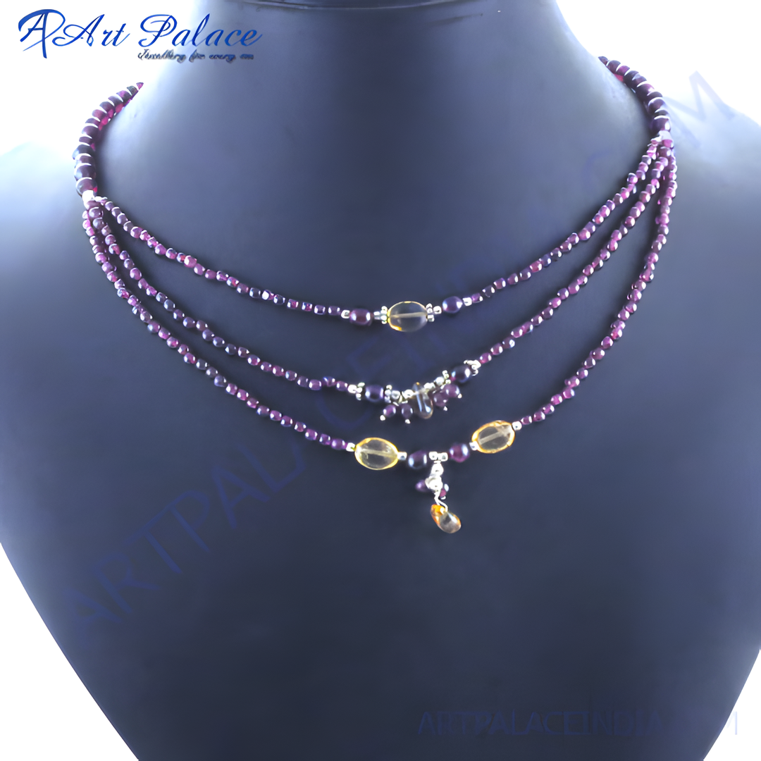Layered necklace with garnet beads on a display mannequin. Features red gemstones and accents.