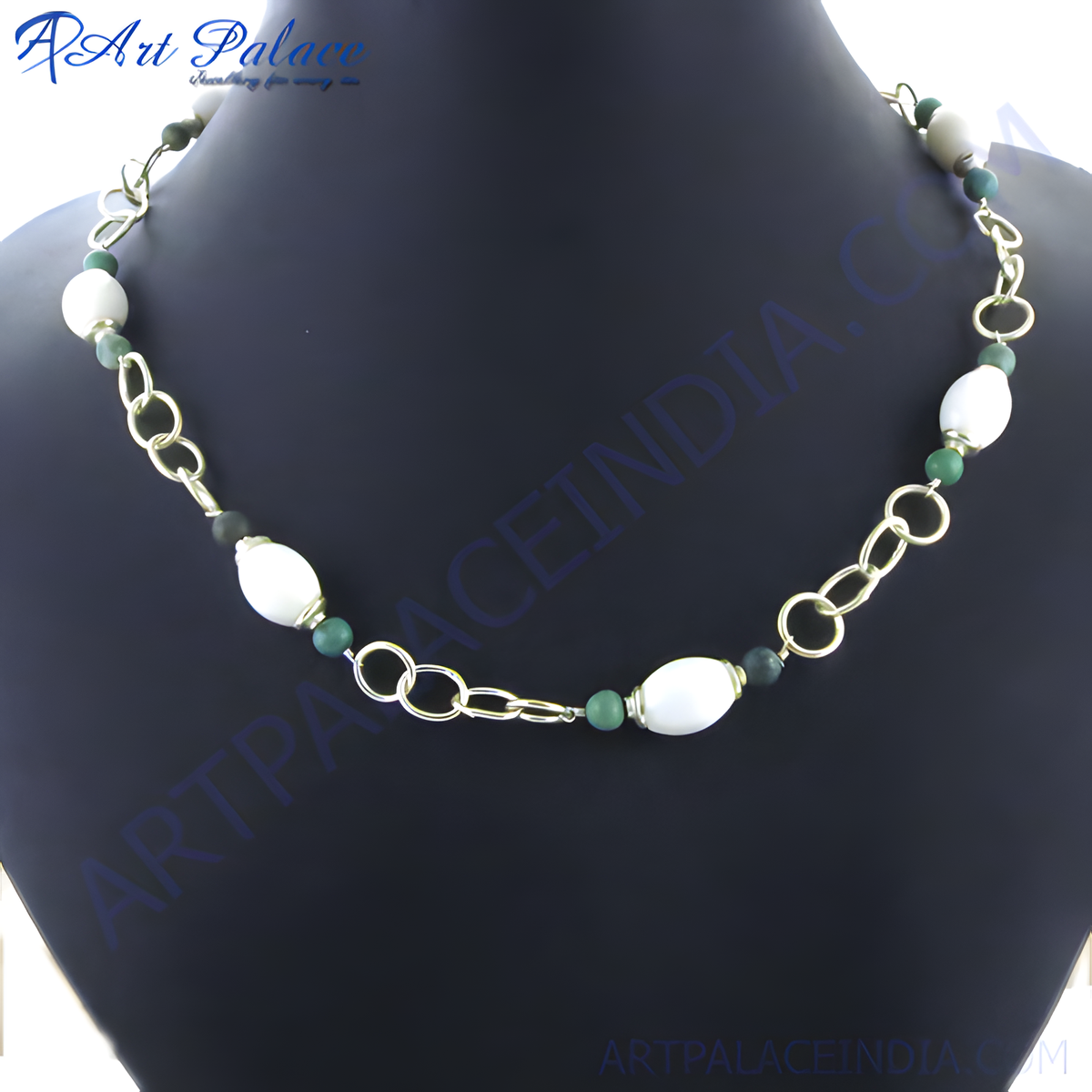 Gold chain necklace with white and green stones displayed on a black background