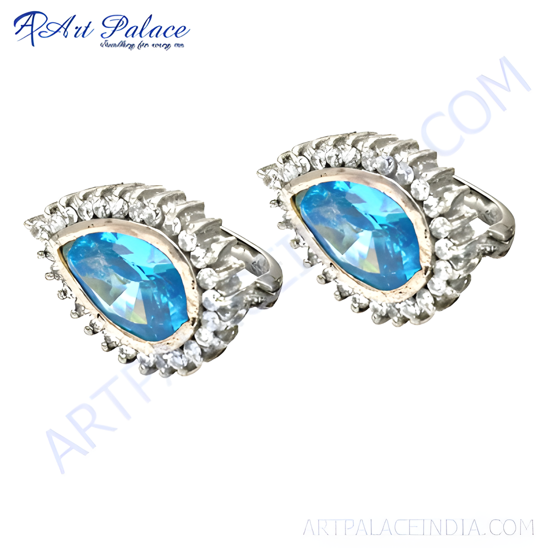 Sterling silver stud earrings featuring a large blue gemstone, surrounded by smaller clear gemstones.
