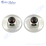 Load image into Gallery viewer, Sterling silver stud earrings with a round, deep red garnet gemstone center on a polished surface
