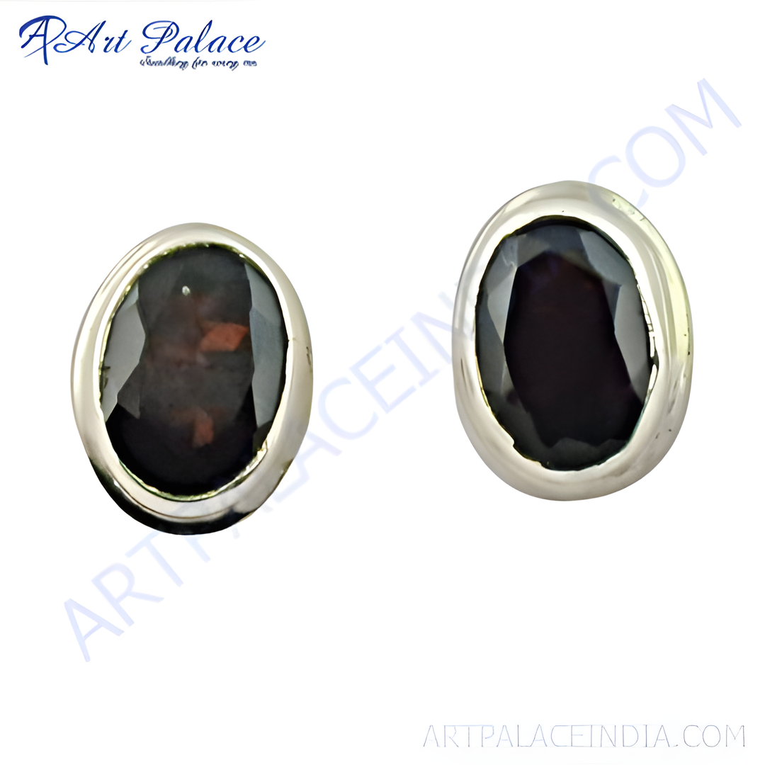 Close-up of silver stud earrings with oval black gemstones set in a silver bezel.
