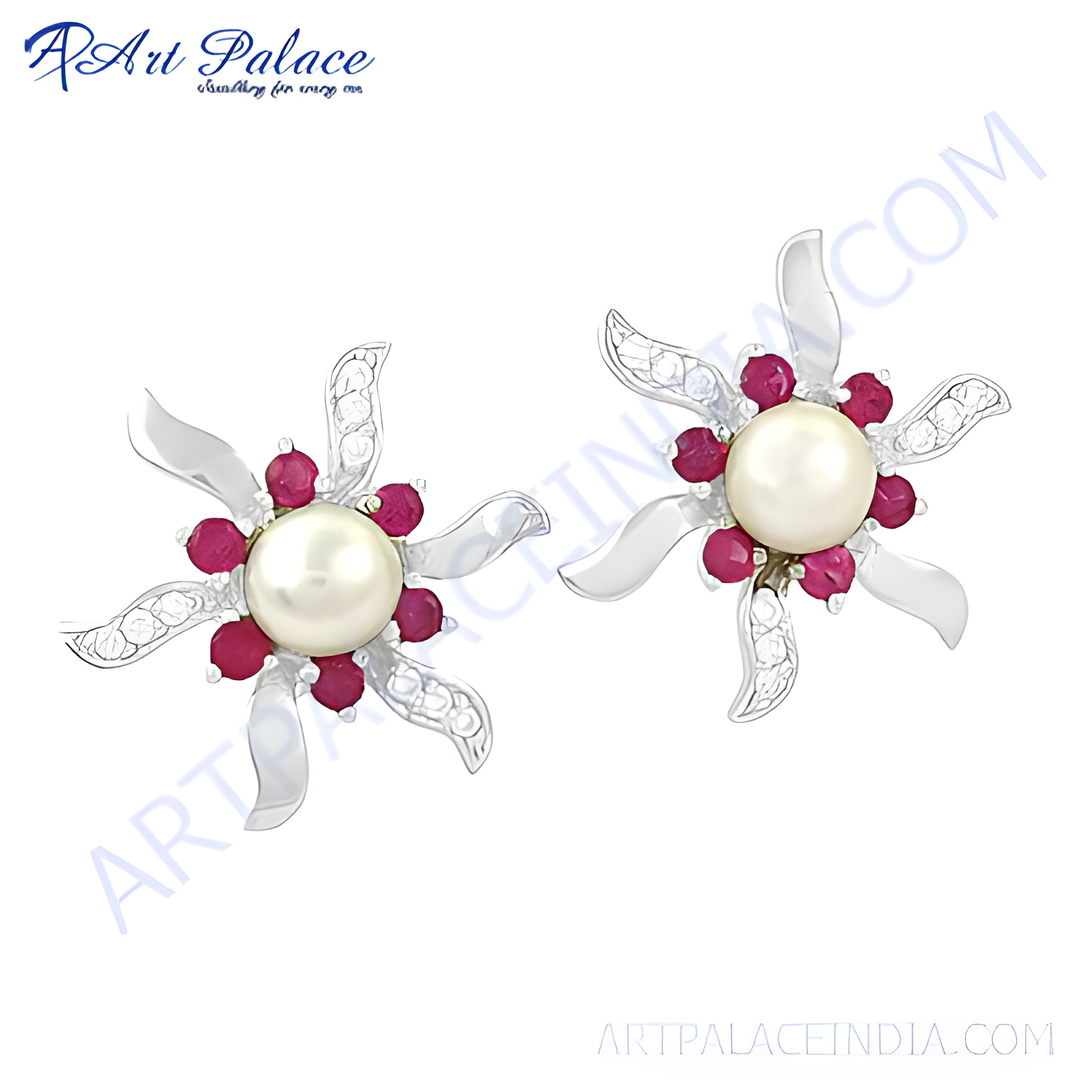 Silver stud earrings featuring a pearl center surrounded by ruby gemstones, designed in a floral shape