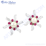 Load image into Gallery viewer, Silver stud earrings featuring a pearl center surrounded by ruby gemstones, designed in a floral shape
