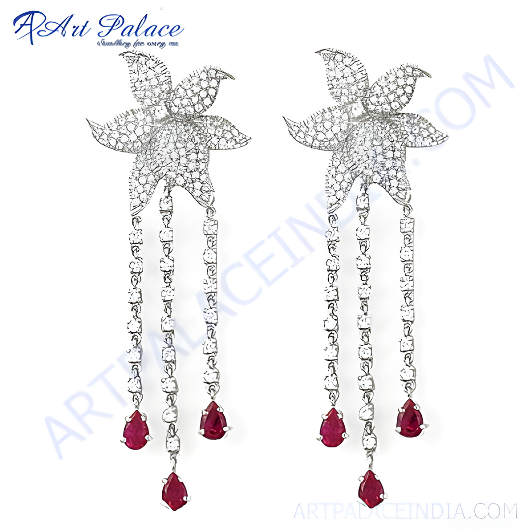 Sterling silver dangle earrings with a flower design and ruby gemstone drops.