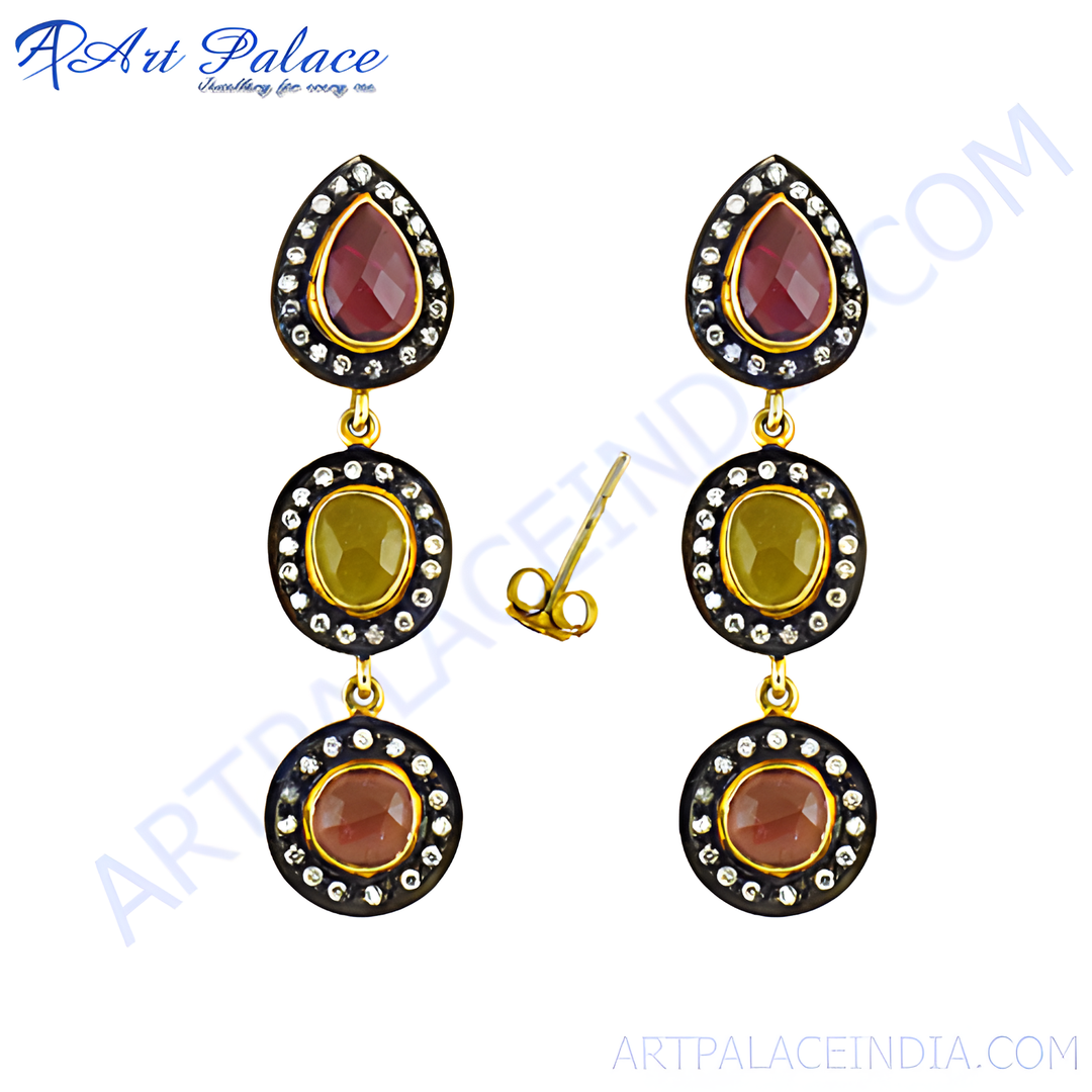 Gold dangle earrings with ruby and sapphire gemstones, perfect for special occasions. Features a secure hook closure.