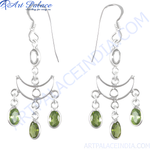 Load image into Gallery viewer, Sterling silver dangle earrings with oval-cut peridot gemstones in a chandelier design.
