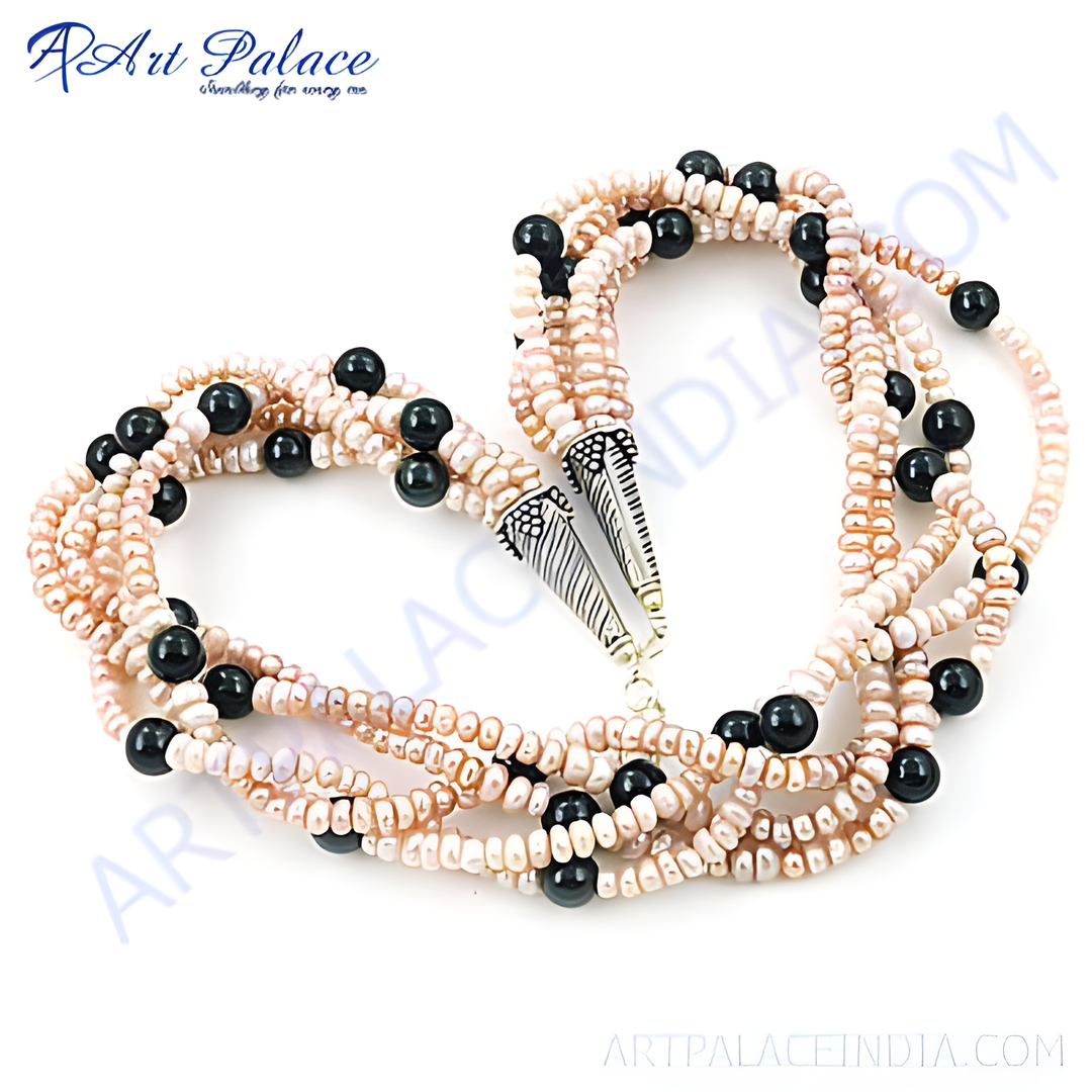 Multi-strand necklace with pink pearls and black onyx beads on white background