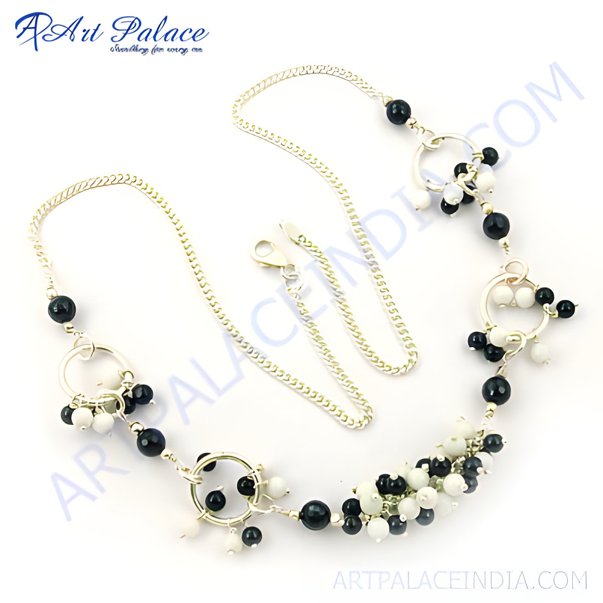 Silver chain necklace with black and white beads on white background