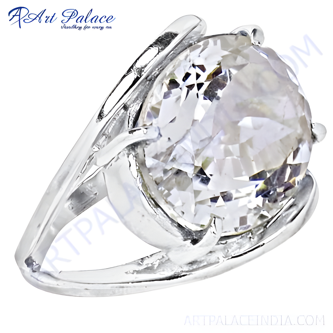 Close-up of a silver ring with a large, faceted white gemstone, sparkling and reflective.