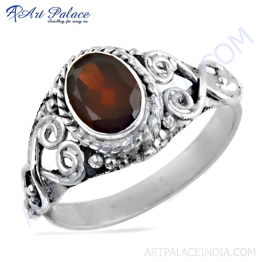 Sterling silver ring featuring an oval garnet gemstone set in a detailed, oxidized silver design.