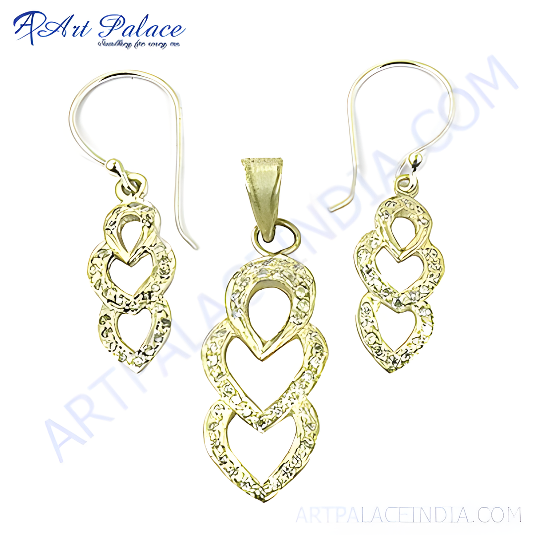 Gold pendant and earrings set with crystal heart design on white background
