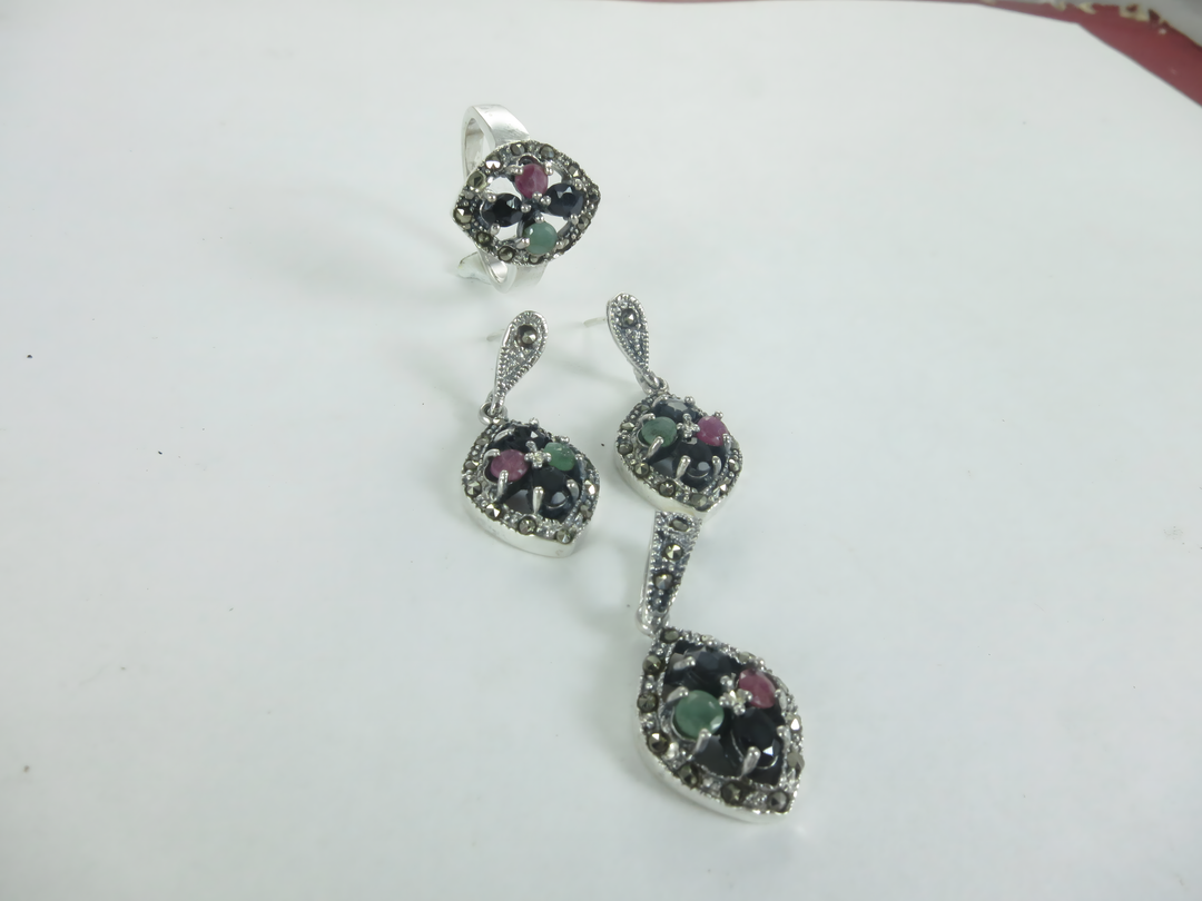 Sterling silver gemstone ring and earrings set with red, green, and black stones.