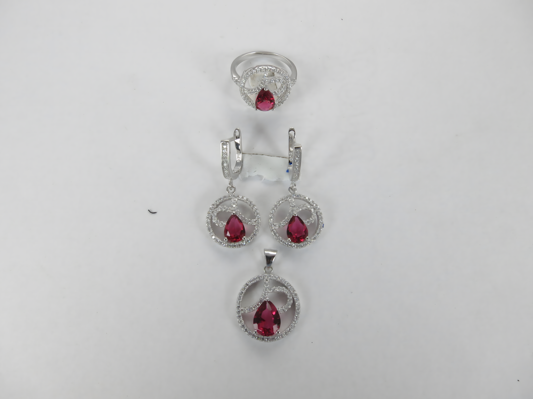Sterling silver jewelry set with ruby red gemstones: ring, earrings, and pendant necklace
