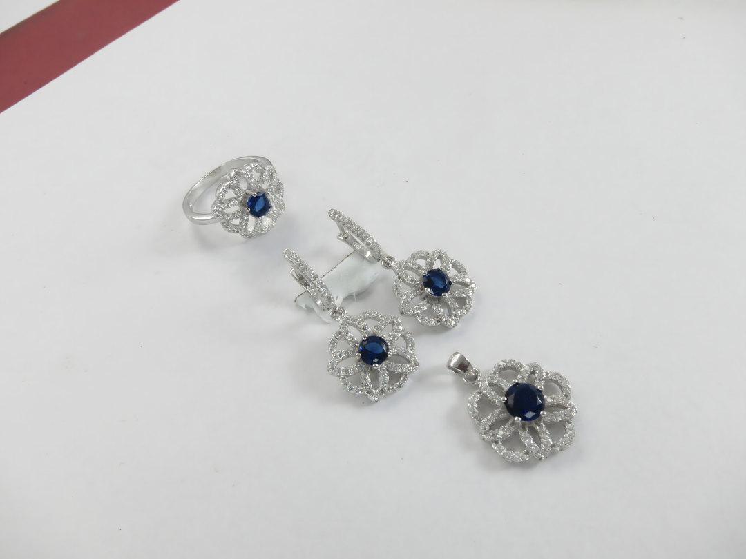 925 sterling silver jewelry set featuring blue sapphire gemstones: ring, earrings, and pendant.
