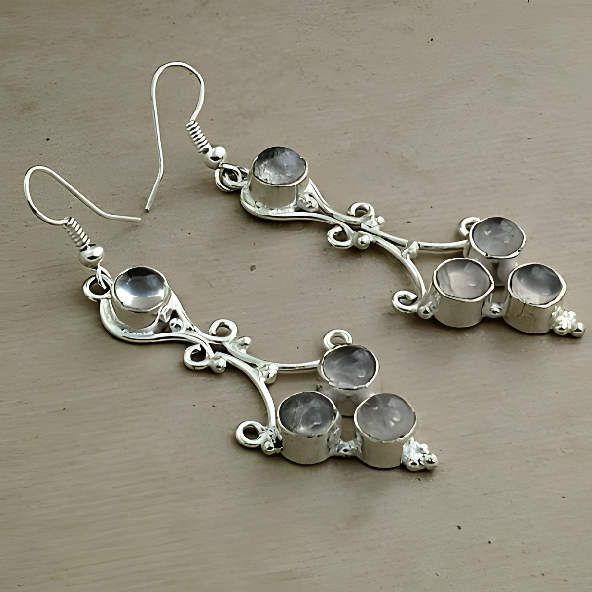 Sterling silver dangle earrings with multiple gemstones on a neutral background