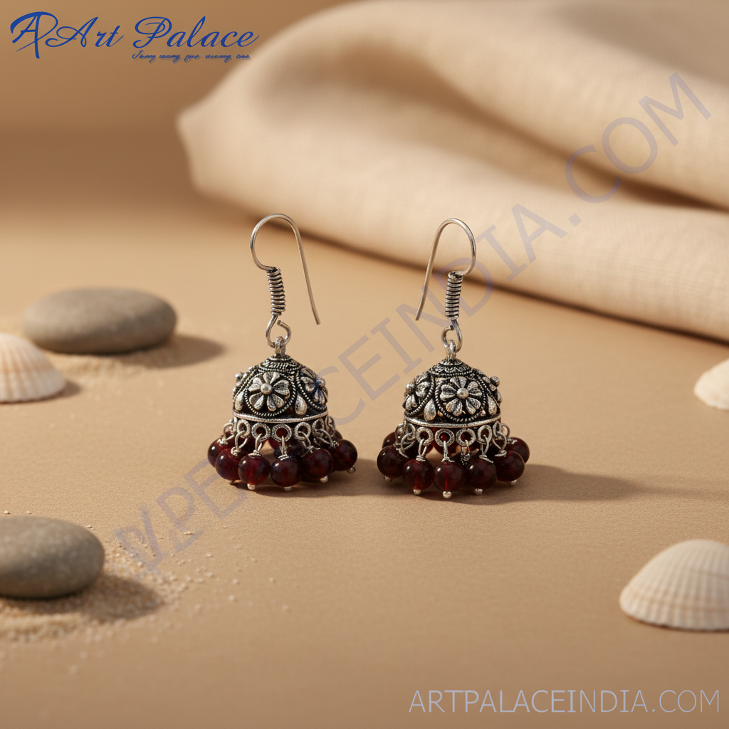 Silver jhumka earrings with ornate design and dangling red beads for women