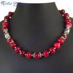 Load image into Gallery viewer, Red beaded necklace on a black jewelry display, showcasing the vibrant red beads and silver accents.

