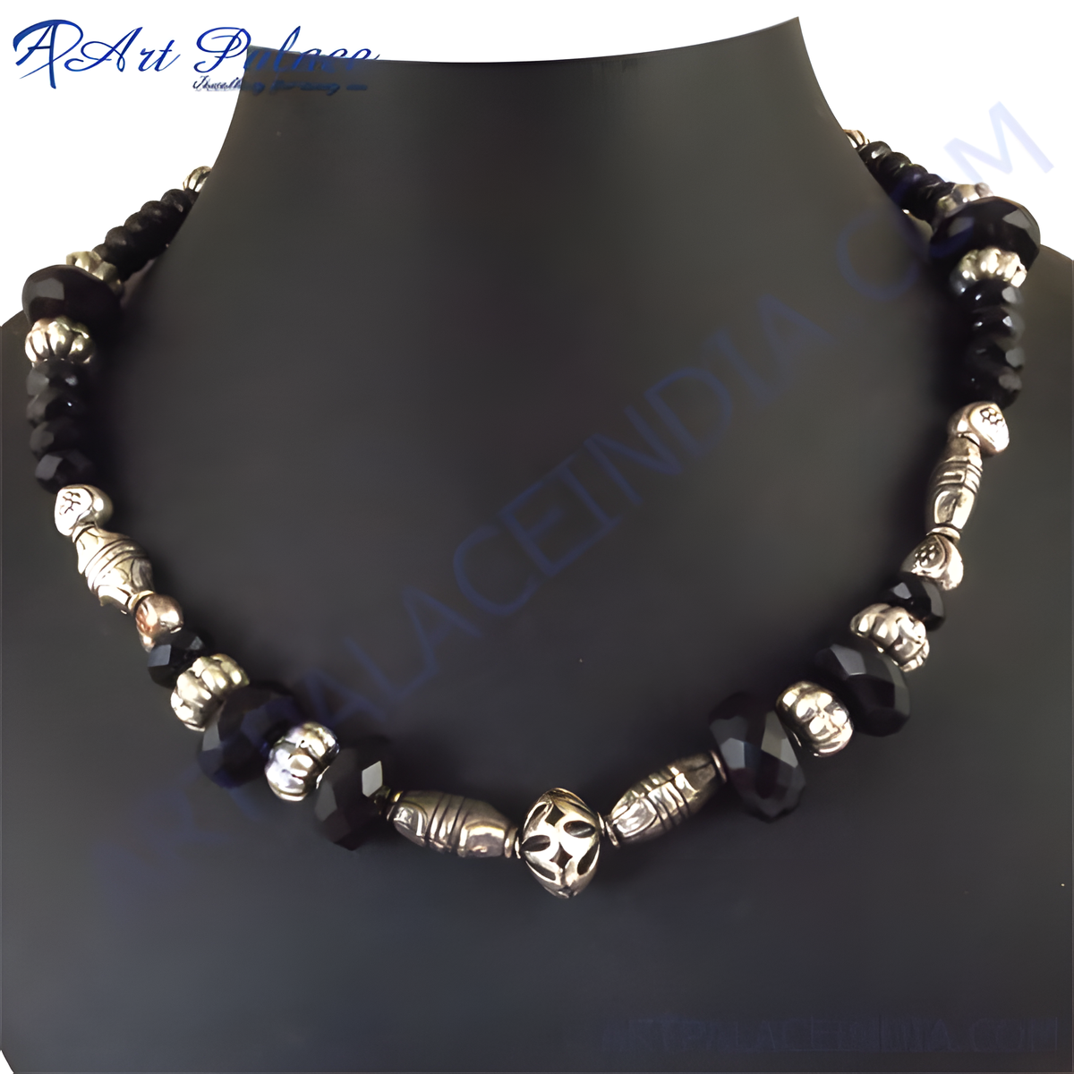 Black onyx beaded necklace with silver accents on a black jewelry display