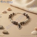 Load image into Gallery viewer, Elegant silver pendant necklace with a central black gemstone and smoky quartz beads on a black bust form.
