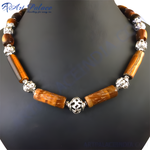 Load image into Gallery viewer, Tiger eye beaded necklace with silver accents on a black background.
