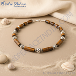 Load image into Gallery viewer, Tiger eye beaded necklace with silver accents on a black background.
