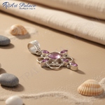 Load image into Gallery viewer, Sterling silver pendant with central gemstone and surrounding pink accent stones, a beautiful piece of jewelry.
